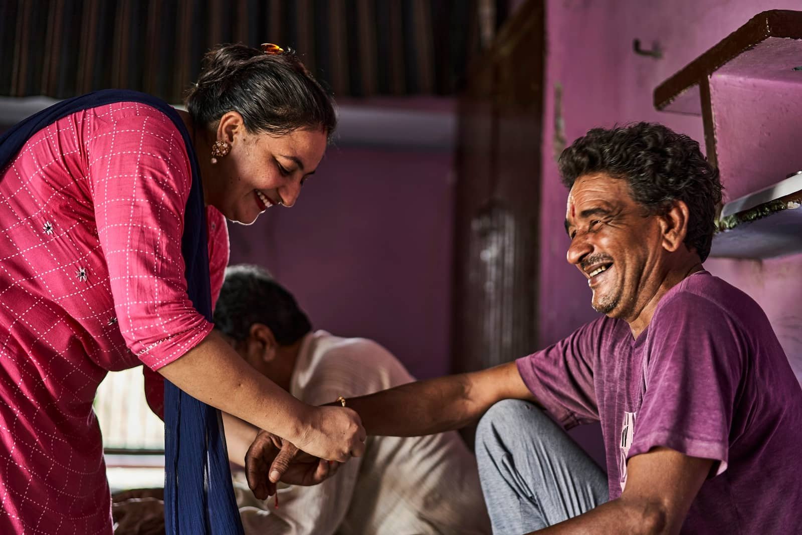 A community health worker checking a man's pulse at a village clinic