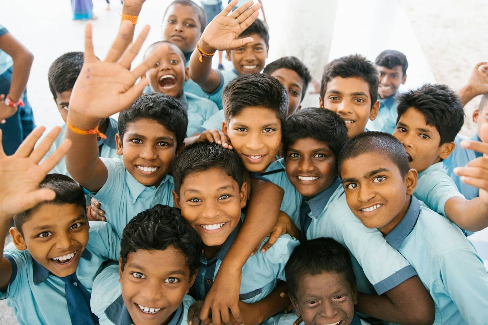 Children in school uniform waving at the camera