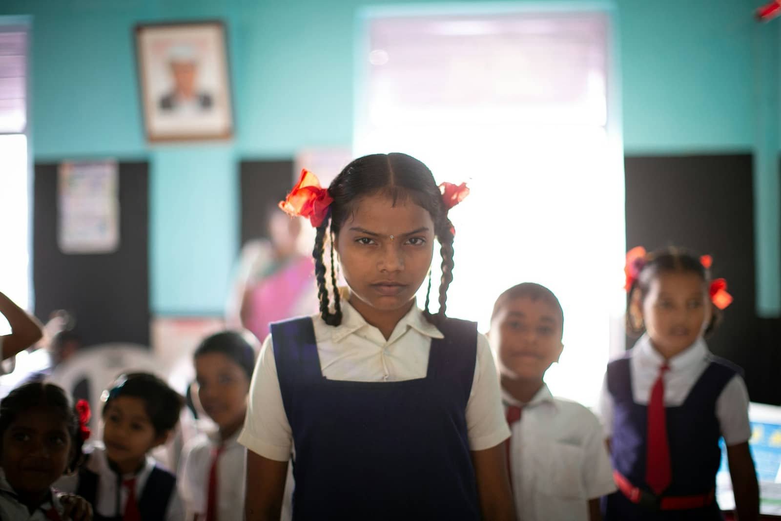 A schoolgirl standing in a classroom with her classmates